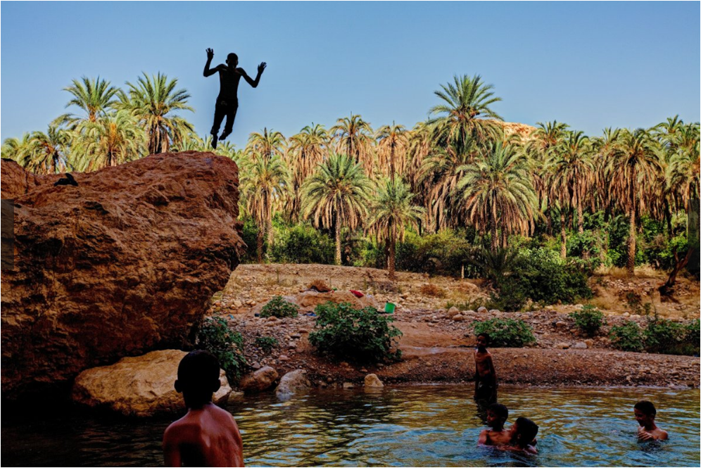 des gamins baignent dans un lac au Sahara.